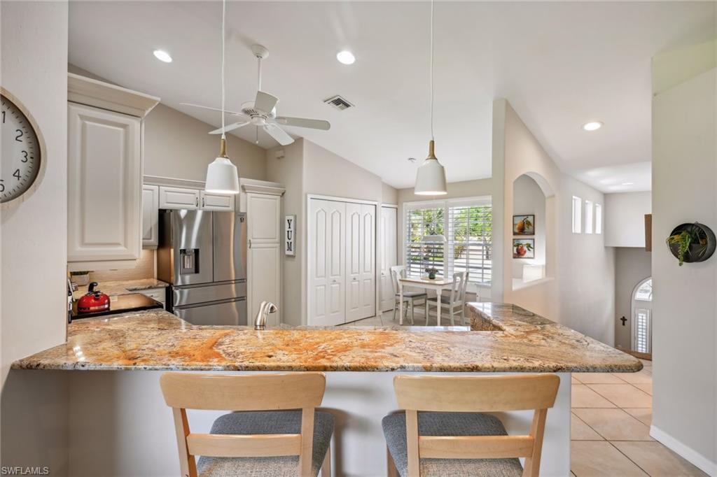 9030 Spring Run Boulevard, Unit 508 Estero, FL 34135 - Photo 8 of 50 a kitchen with kitchen island granite countertop a table and chairs in it