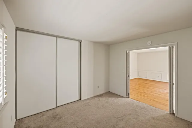 a bed sitting in a bedroom next to a window