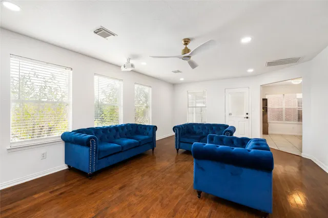 a living room with couches and large window with wooden floor