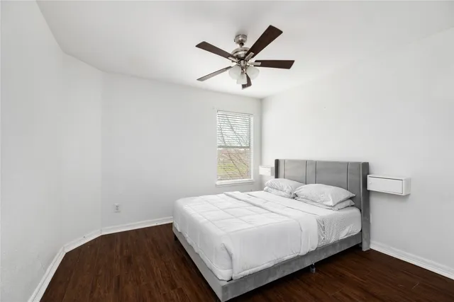 a bedroom with a large bed and a ceiling fan