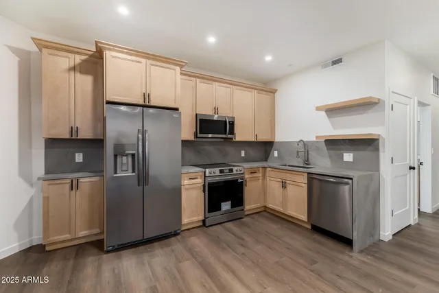 a kitchen with stainless steel appliances granite countertop a stove and a refrigerator