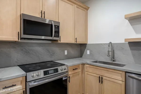 a kitchen with stainless steel appliances granite countertop a refrigerator stove and sink