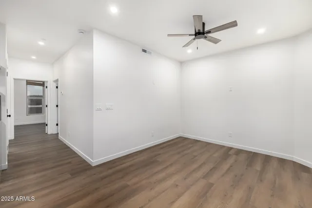a view of a room with wooden floor and a ceiling fan