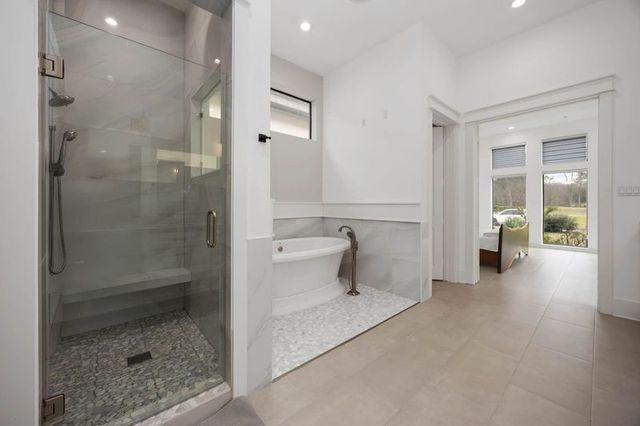a spacious bathroom with a granite countertop sink mirror and bathtub