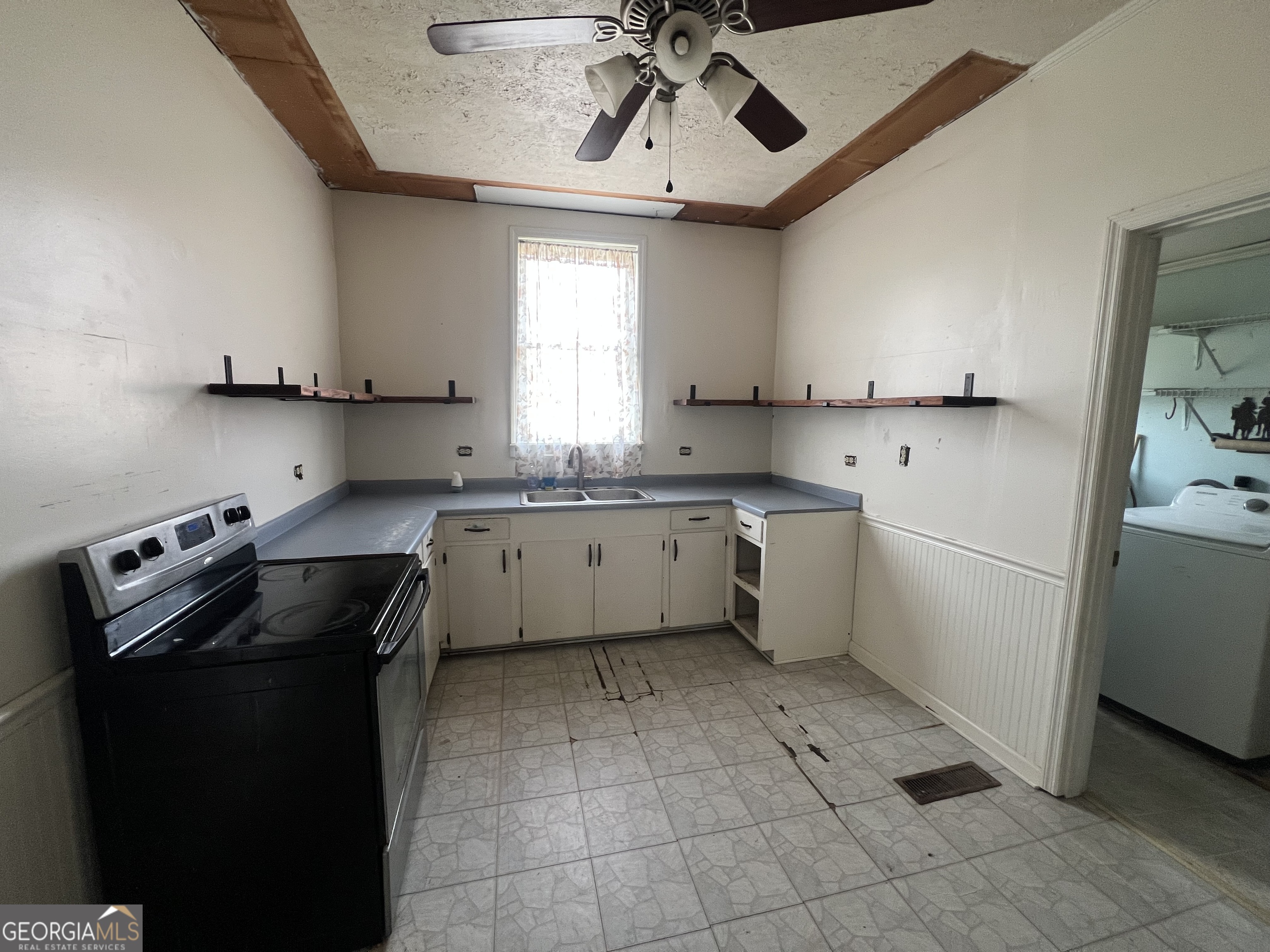 179 Independence Street Tignall, GA 30668 - Photo 6 of 21 a kitchen with a sink a stove cabinets and a window