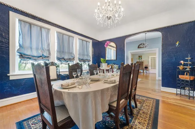 a dining room with furniture a chandelier and wooden floor