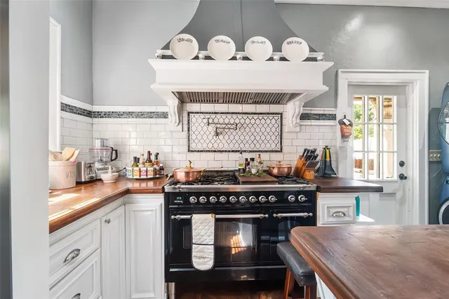 a kitchen with a stove a sink and a wooden cabinets