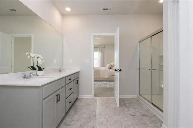 a en suite bathroom with a granite countertop sink and a mirror