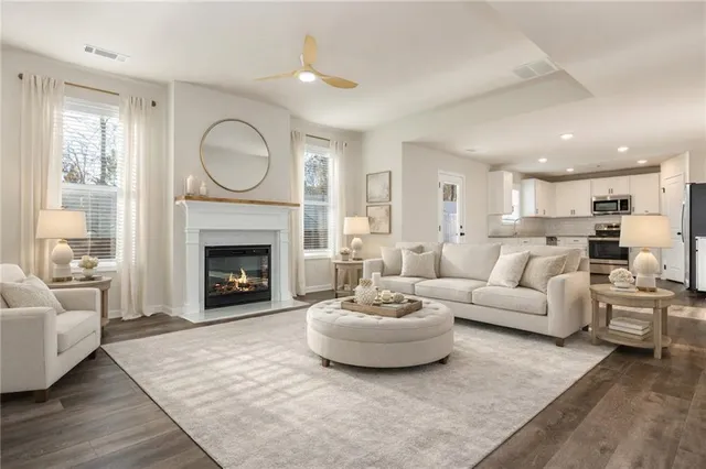 a living room with furniture a fireplace a rug and a large window