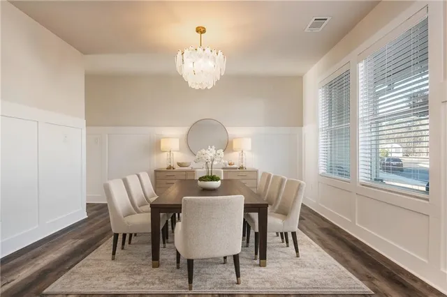 a view of a dining room with furniture a chandelier and wooden floor