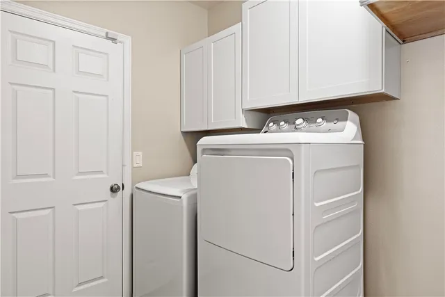 a kitchen with stainless steel appliances white cabinets and wooden floor