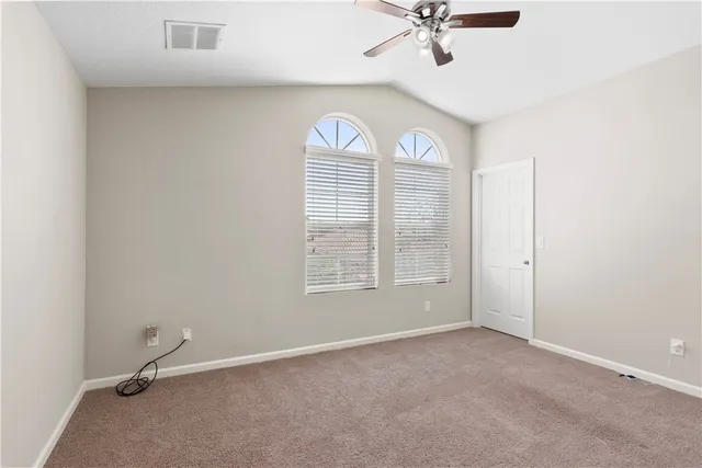 a bedroom with a bed and a flat tv screen on the dresser