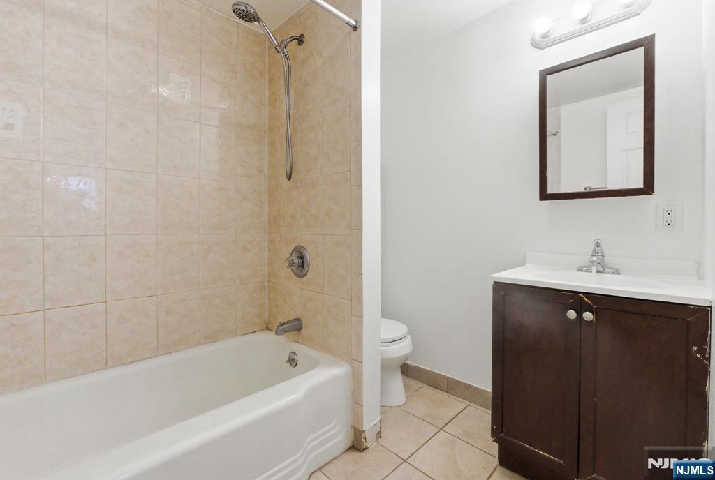 64 John Ryle Avenue Haledon, NJ 07508 - Photo 20 of 44 a bathroom with a sink mirror toilet and bathtub