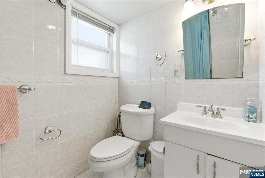 64 John Ryle Avenue Haledon, NJ 07508 - Photo 29 of 44 a bathroom with a toilet sink and mirror