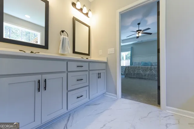 a en suite bathroom with a granite countertop sink and a mirror
