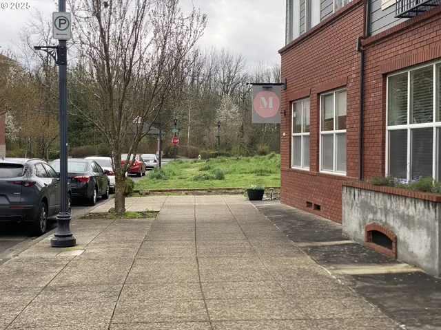 a view of a building with cars parked on road