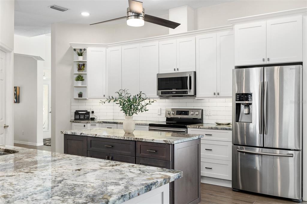 2513 Regal River Road Valrico, FL 33596 - Photo 13 of 46 a kitchen with kitchen island granite countertop a sink appliances cabinets and counter space