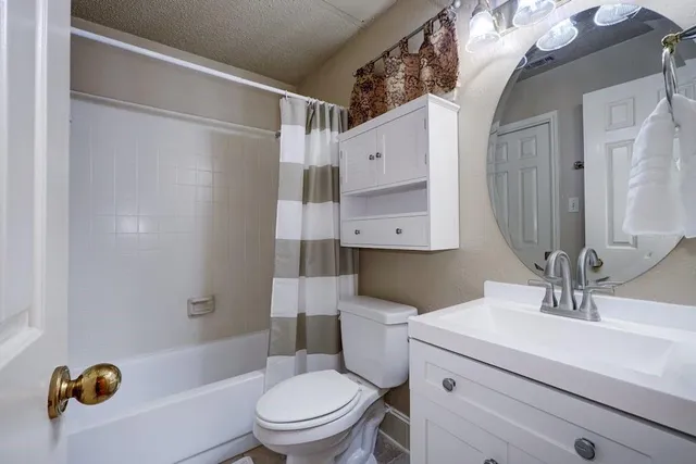 a bathroom with a sink a mirror a toilet and shower