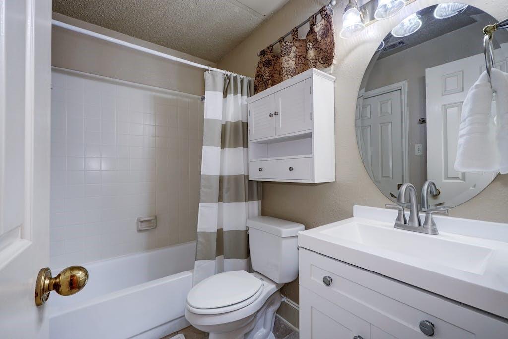 3001 Cedar Street, Unit 204 Austin, TX 78705 - Photo 16 of 20 a bathroom with a sink a mirror a toilet and shower