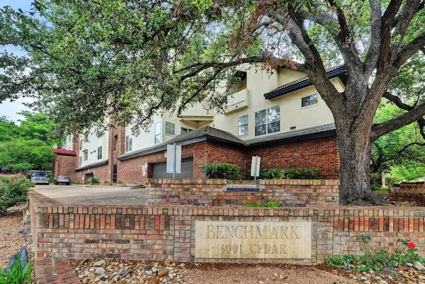 a front view of a house with a tree