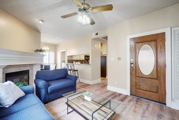 a living room with furniture a fireplace and a chandelier
