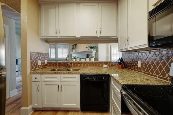 a kitchen with granite countertop a stove and a microwave
