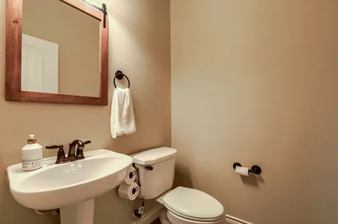 a bathroom with a sink a toilet and mirror