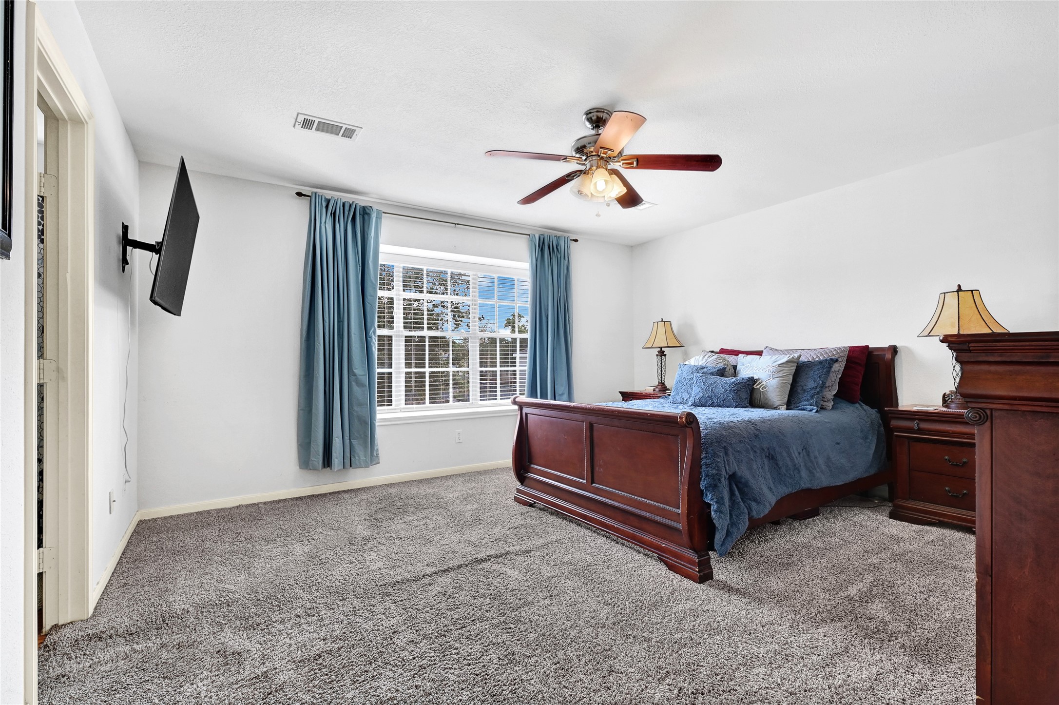 10100 Spring Pl Drive Houston, TX 77070 - Photo 12 of 24 a bedroom with a bed and a chandelier