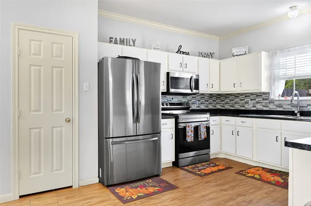 a kitchen with stainless steel appliances granite countertop a refrigerator and a stove top oven