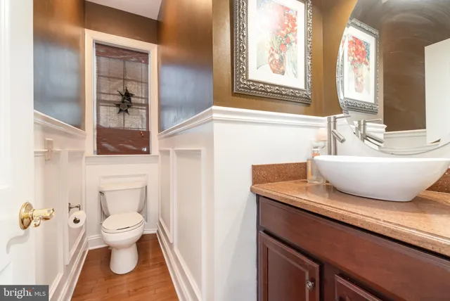 a bathroom with a sink a toilet and a large mirror