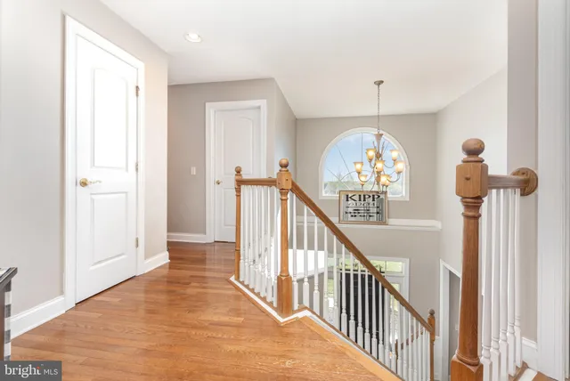 a view of a hallway with wooden floor and entryway