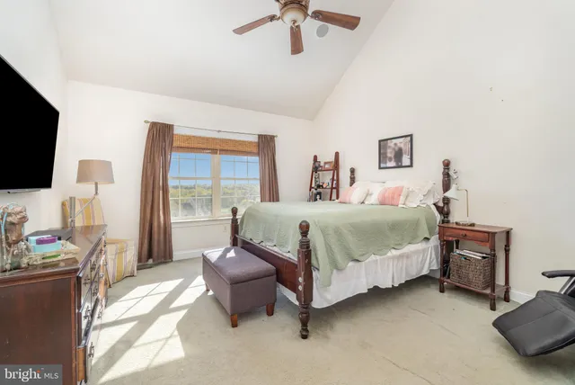 a bedroom with a bed window and a flat screen tv