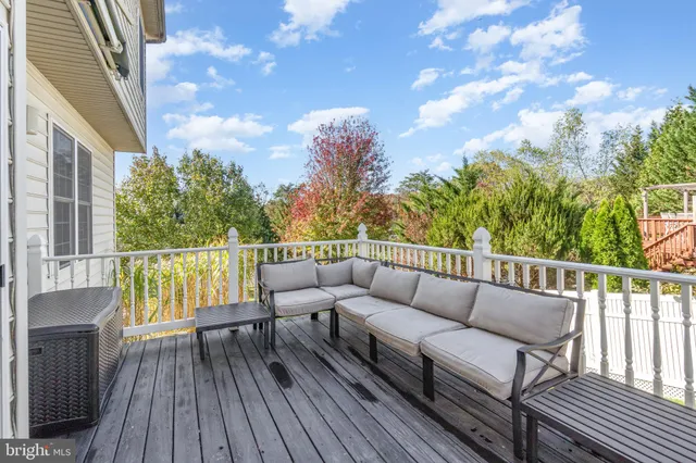 a balcony with wooden floor and outdoor seating