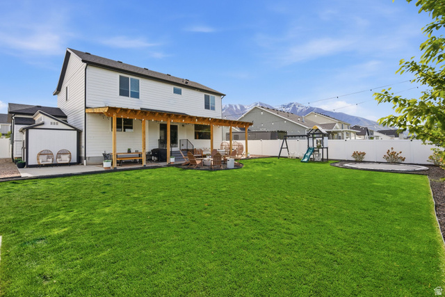 596 South Meade Street Mapleton, UT 84664 - Photo 31 of 38 Rear view of property featuring a patio area, a fenced backyard, a mountain view, and a playground