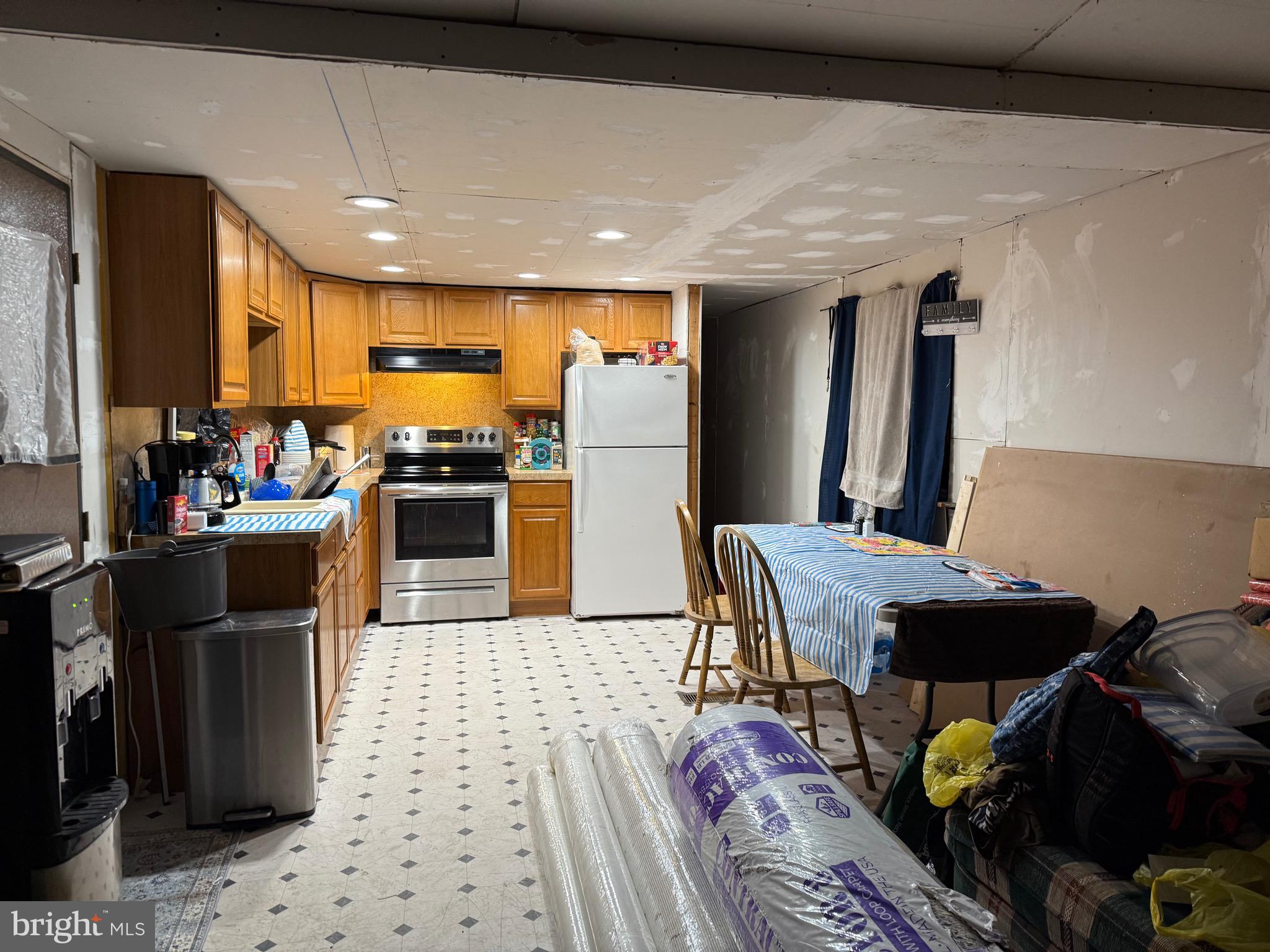 1910 Schubert Road, Unit 4 Bethel, PA 19507 - Photo 9 of 14 a kitchen with stainless steel appliances granite countertop a refrigerator a stove a sink a dining table and chairs with wooden floor