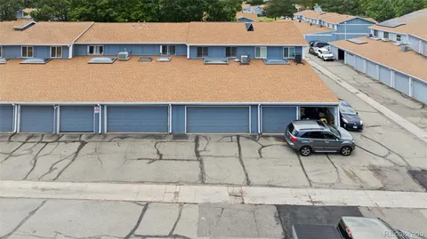 an aerial view of a house with garden space and a car parked