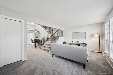 a living room with furniture and stairs