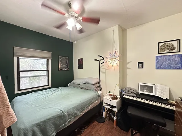 a bedroom with a bed piano and a window