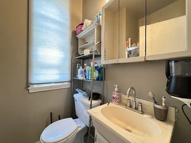 a bathroom with a sink a toilet and a mirror