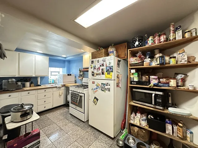a kitchen with a refrigerator and a stove top oven