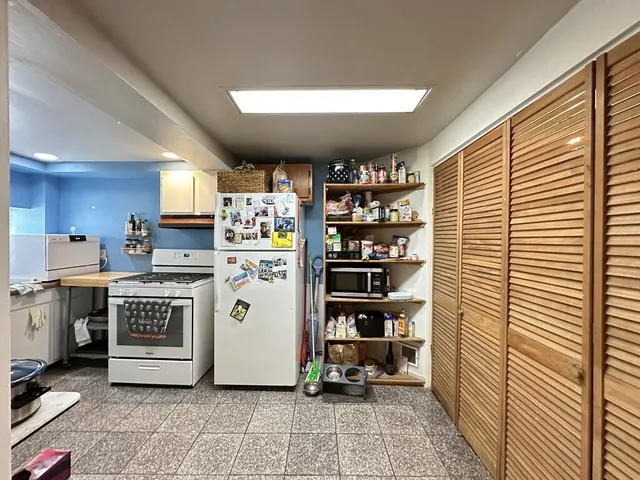 a kitchen with a refrigerator and white cabinets