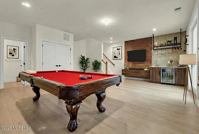 a room with furniture pool table flat screen tv and windows
