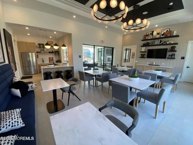 a living room with furniture a flat screen tv and kitchen view