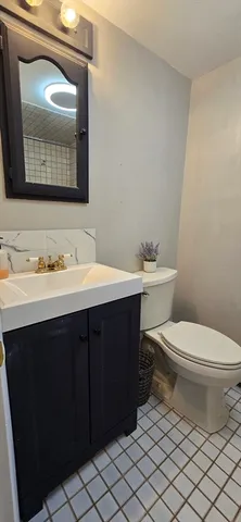 a bathroom with a toilet sink vanity and mirror