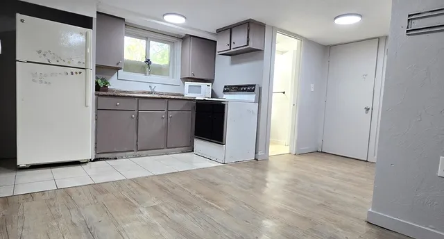 a kitchen with granite countertop a refrigerator and a sink