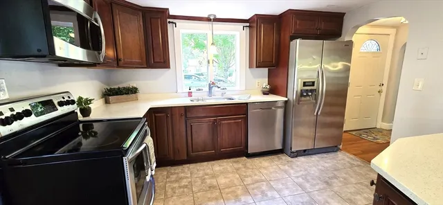a kitchen with granite countertop a refrigerator stove and sink
