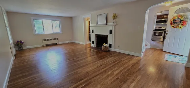 a view of a room with wooden floor and a fireplace