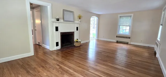 an empty room with wooden floor and fireplace
