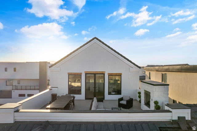 5367 Cyan Lane St. George, UT 84790 - Photo 38 of 49 Rooftop deck featuring an outdoor fireplace, a spacious patio area, black-framed glass doors, and durable white exterior siding