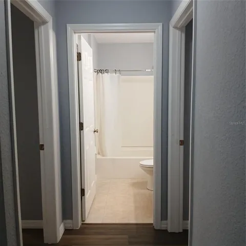 an empty room with wooden floor and closet
